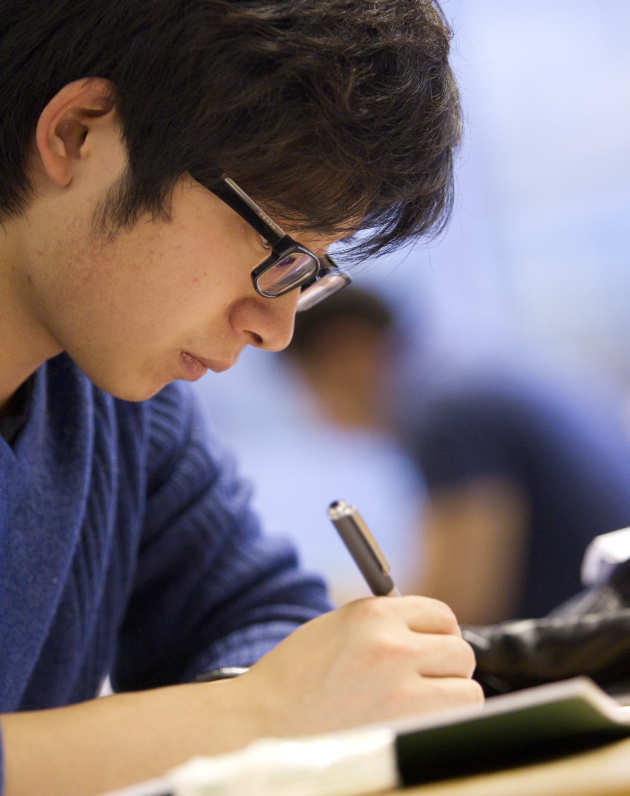 Student writing on paper